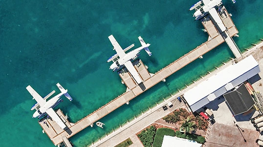 blade-sec-img-01 Aerial view of seaplanes docked at a tropical waterfront marina